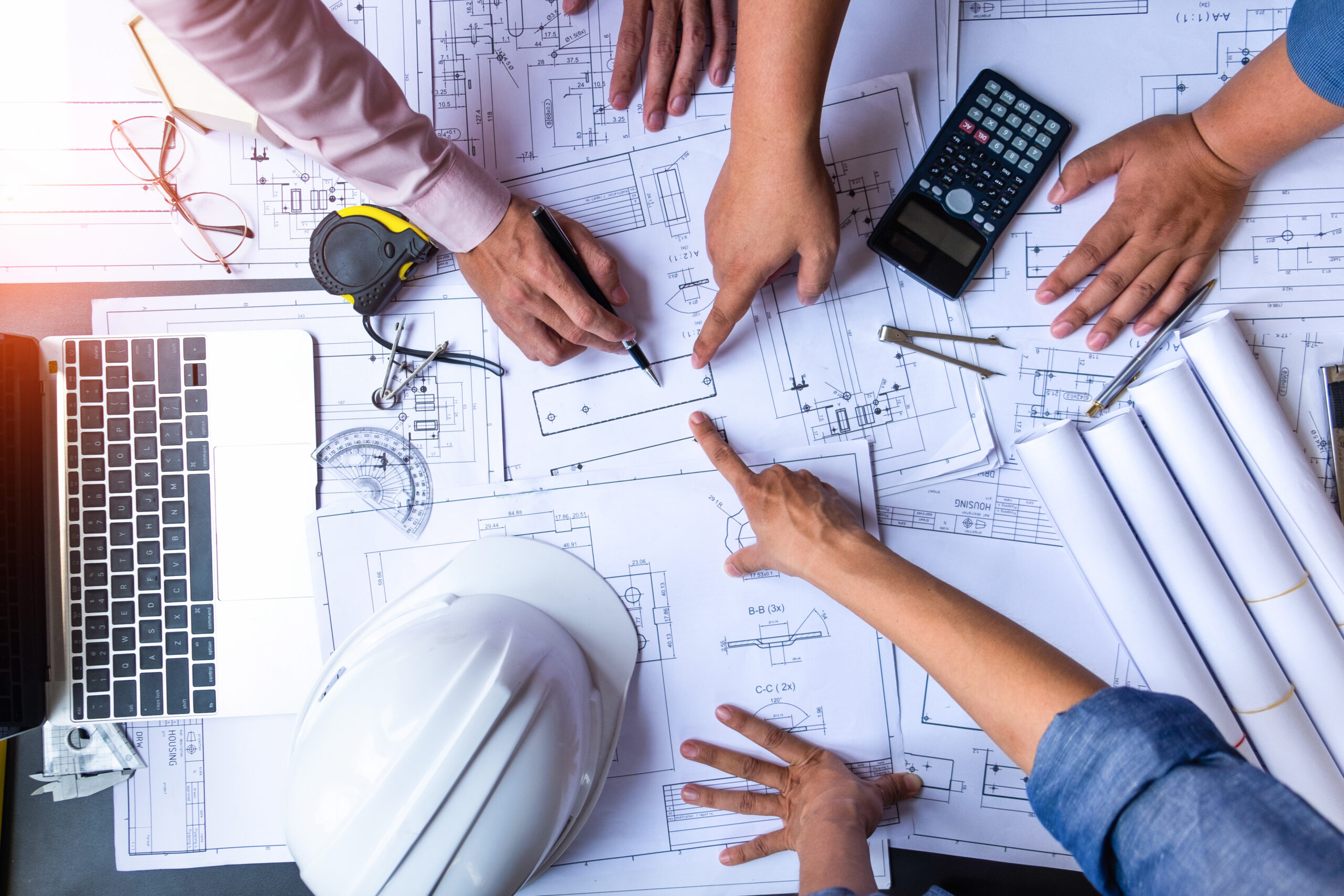 Architects/builders reviewing blueprints and construction plans together
